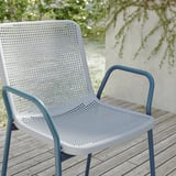 Moderna cadeira de patio azul claro con asento branco perforado, marco de aceiro revestido en po, apto para uso ao aire libre.