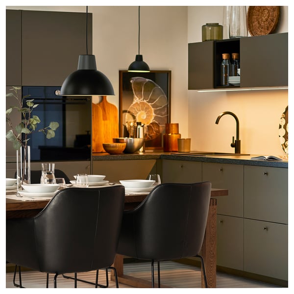 Cociña moderna con cadeiras de coiro negro TOSSBERG, mesa para comedor, luces colgantes negras, mesa gris con decoración.