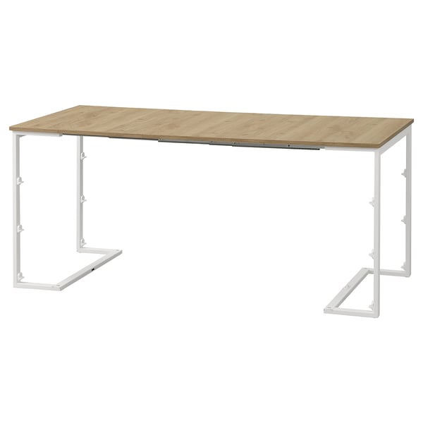 Unha mesa de comedor convertible TRÄKUMLA en marrón claro cun marco metálico branco, deseñada para espazos pequenos.