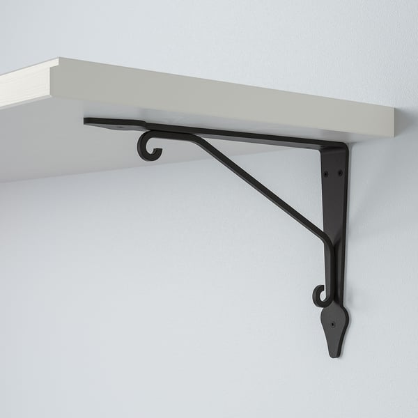 Un elegante estante montado na parede cun robusto soporte metálico. Estante branco, soporte negro, montado de forma segura nunha parede lisa.