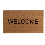 Alfombra de benvida, coir marrón, forma rectangular, letras negras grosas.