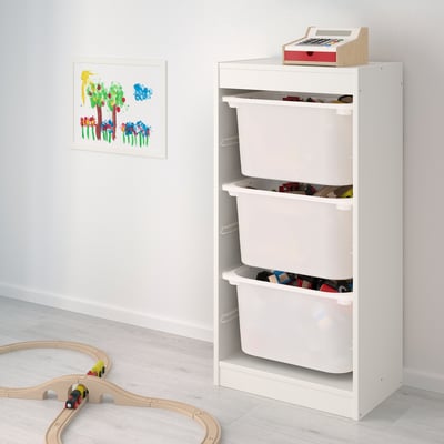 Unidade de almacenamento branco TROFAST con tres caixóns, cada un con varios xoguetes infantís. Perfecto para a organización e o fácil acceso.
