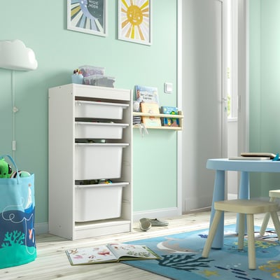 Unidade de almacenamento branco TROFAST no cuarto dos nenos, con múltiples estantes e xoguetes.