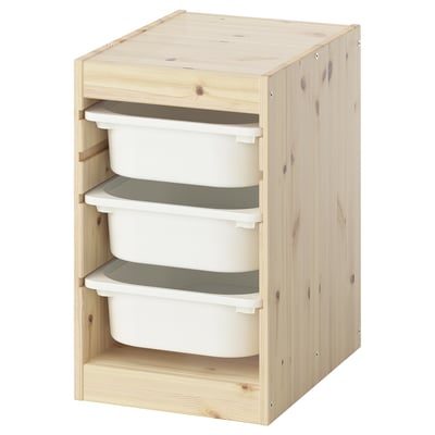 Unha unidade de almacenamento de madeira de cor natural IKEA TROFAST con recipientes de plástico branco, axeitado para organizar xoguetes infantís.
