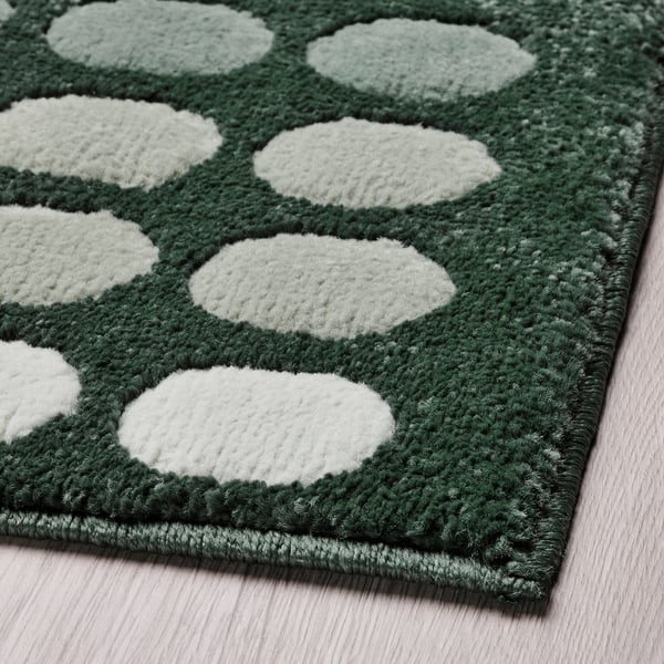 Alfombra de puntos de textura verde e branca, duradeira, invita á calor.