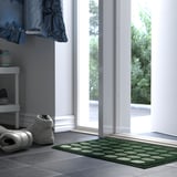Corredor con alfombra verde TUNNELBANA, zapatillas e porta de vidro.