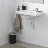 Lavabo branco moderno montado na parede con toalla, soporte de cepillo de dentes, prato de xabón e billa cromada. Fondo branco.