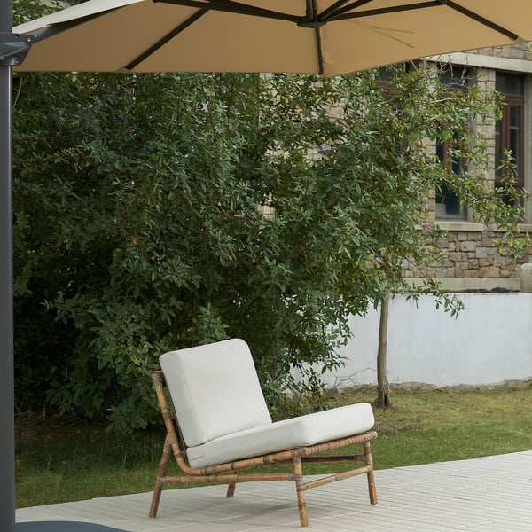 Cadeira exterior TVARÖ: coxín beige claro, marco de vimbio, asento único, deseño aireado, axústase a espazos pequenos.