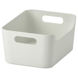 Unha caixa de almacenamento branca con dous mangos. A súa forma cadrada con esquinas redondeadas, útil para organizar e transportar obxectos.