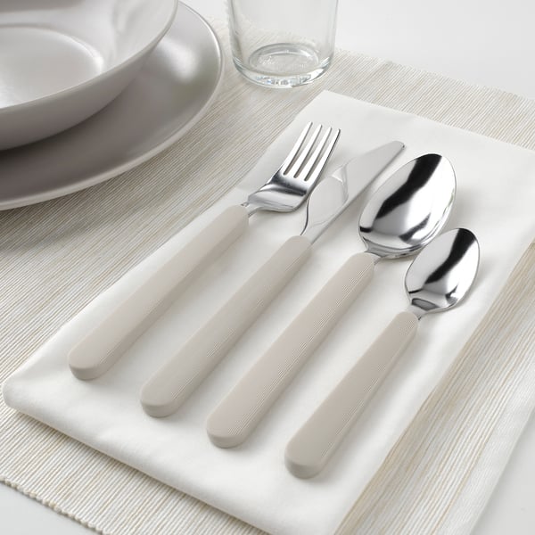 Conxunto de pratería: garfo, coitelo, culler, cucharadita de té en servilleta beige, mangos antideslizantes.