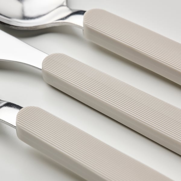 Tres pezas de cubertas beige colocadas ordenadamente; coitelo, garfo e culler con mangos texturizados lisos e antideslizantes.