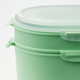 Dous recipientes de plástico verde aniñados un dentro do outro con tapas seguras, ideais para empaquetar o xantar.