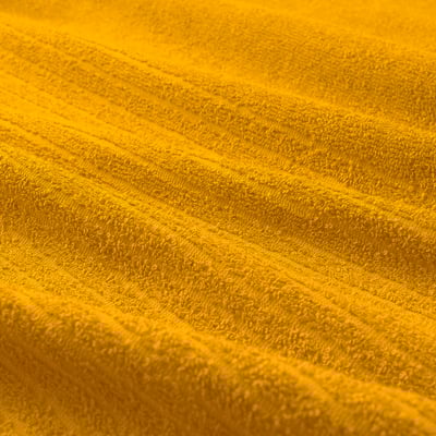Toalla VÅGSJÖN amarela brillante, grosa e suave, dobrada ordenadamente, mostra raias texturizadas, algodón puro.