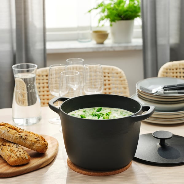 Mesa de comida con sopa, pan e cuberteiras.