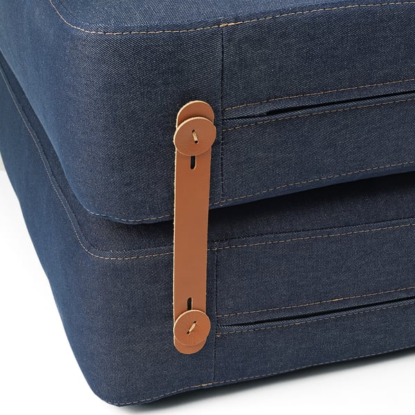 Primeiro plano dunha elegante cama de cadeira de denim con robustas correas de coiro marrón e fixacións metálicas seguras, mostrando artesanía de alta calidade.