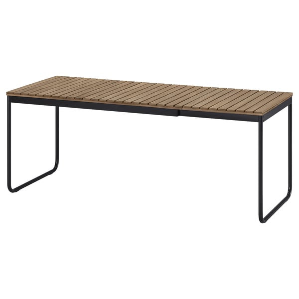 Mesa ao aire libre VÄSMAN, rectangular, madeira marrón clara, marco metálico negro, deseño minimalista.