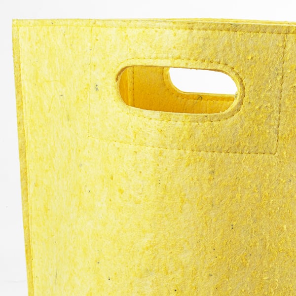 Primeiro plano de bolsa amarela brillante con mango ovalado grande e liso.