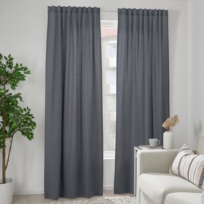 Sala moderna con cortinas grises VÄXELBRUK, cadeira branca, planta e decoración.