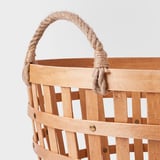 Cesta tecida feita a man con robusto mango de corda e base de madeira, mostrando artesanía de alta calidade e materiais naturais.