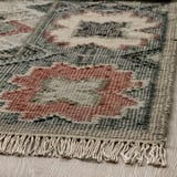 Alfombra tecida a man con patróns intrincados, con tons suaves e la resistente. Franxas nos extremos, mostrando artesanía e calidade.