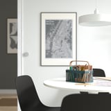 Mesa de comedor moderna con cadeira negra, organizador VIMPELFISK, cartel de mapas, lámpada colgante, obra de arte.