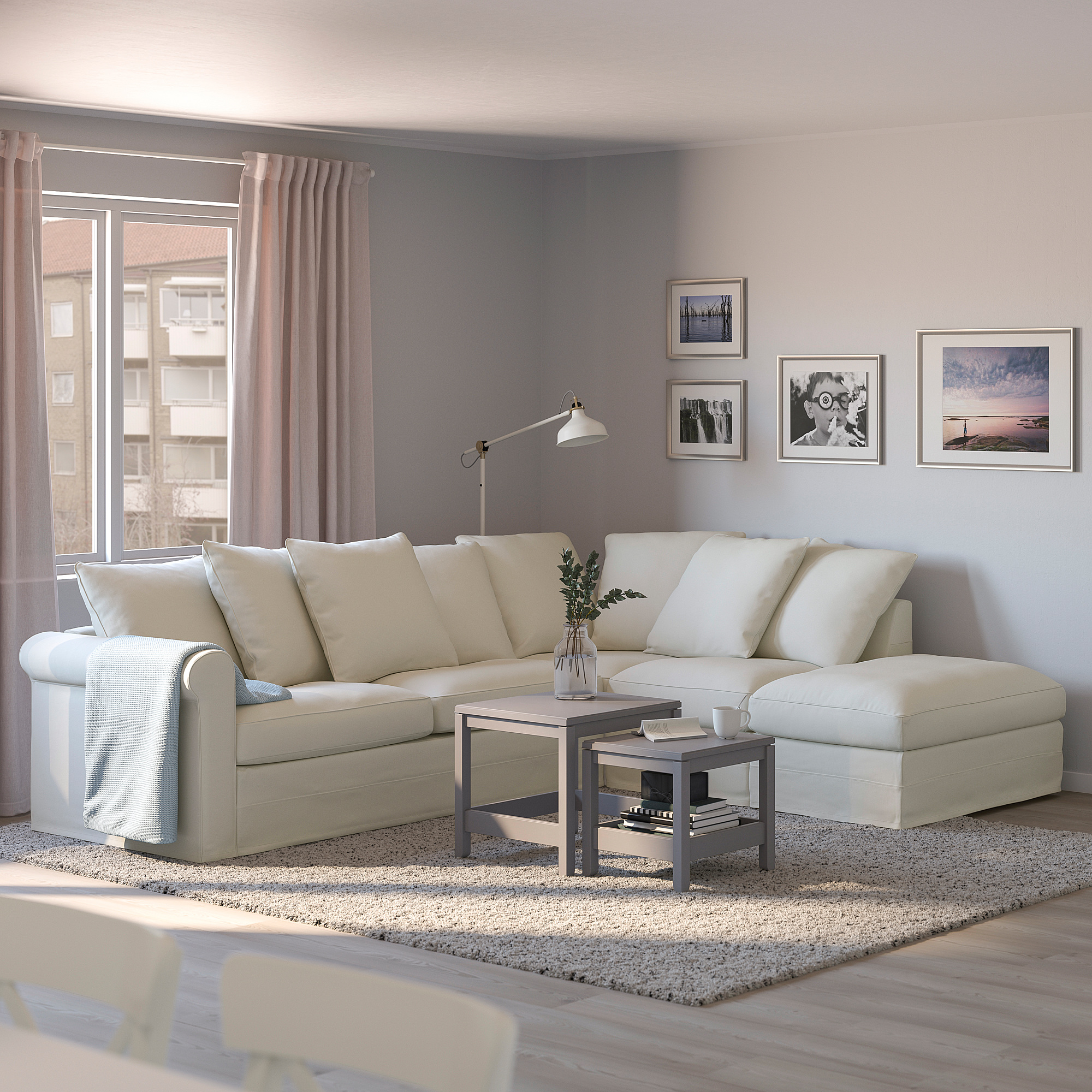 Sala de estar moderna con sofá crema, cortinas rosas, mesa de café e parede chea de arte.