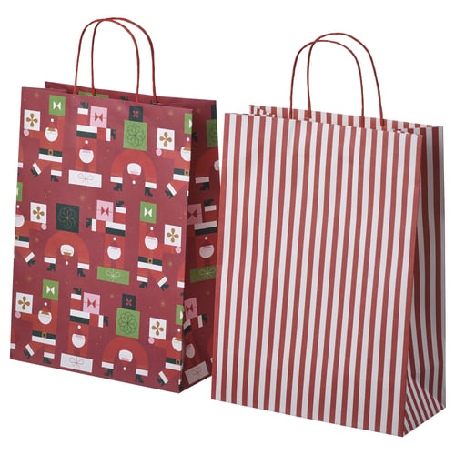 Dúas bolsas festivas, unha vermella con patróns de vacacións, a outra de raias vermellas e brancas, feitas de papel, mostradas de pé.