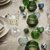 Mesa de Nadal con portavelas de vidro VINTERFINT verde, adornos e vasos transparentes. Soportes en forma de cinta, tamaño medio entre decoración.