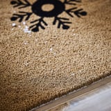 Alfombra táctil con deseño de folerpas de neve, feita con fibras naturais de coir.