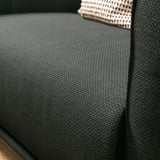 Un primeiro plano dun tecido de cadeira de brazos VISKAFORS gris escuro e texturizado. Deseño de asento suave e redondeado.