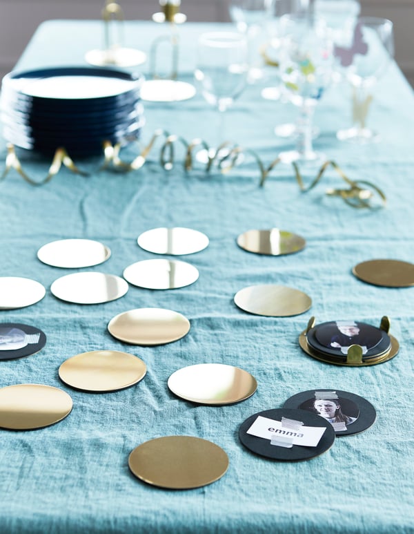 A large collection of brass coloured drinks stands on a table set for a party. 