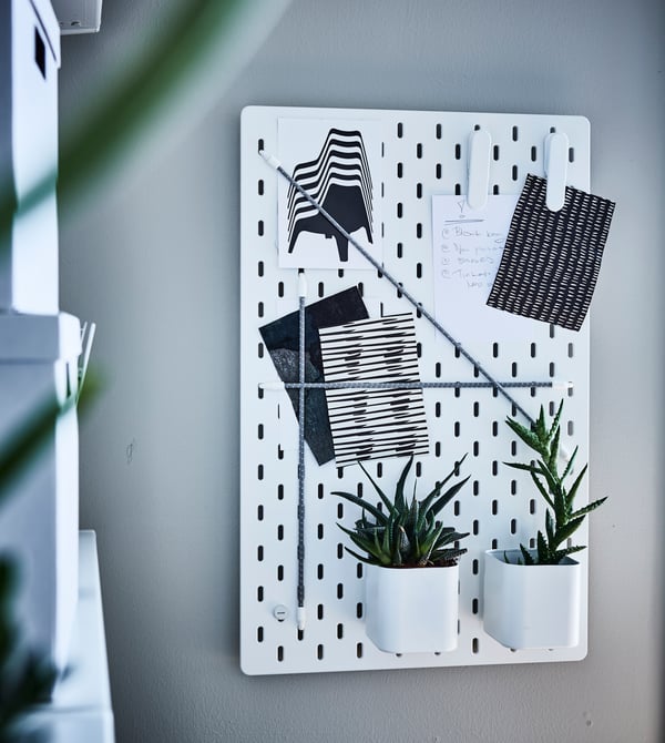 Organise your home workspace with smart home office furniture! Use a pegboard for both storing office supplies and displaying your favourite things. Try the IKEA SKÅDIS pegboard. Then complete it with the different removable accessories you need.