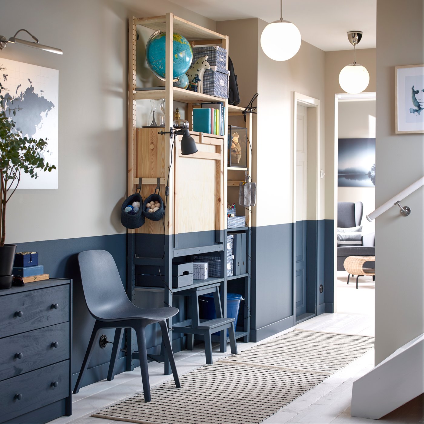 I en gang står en IVAR reol er blevet malet halvvejs blåt så det matcher malingen på væggen og den blå skammel og blå stol og blå kommode der også står i rummet op ad væggen.