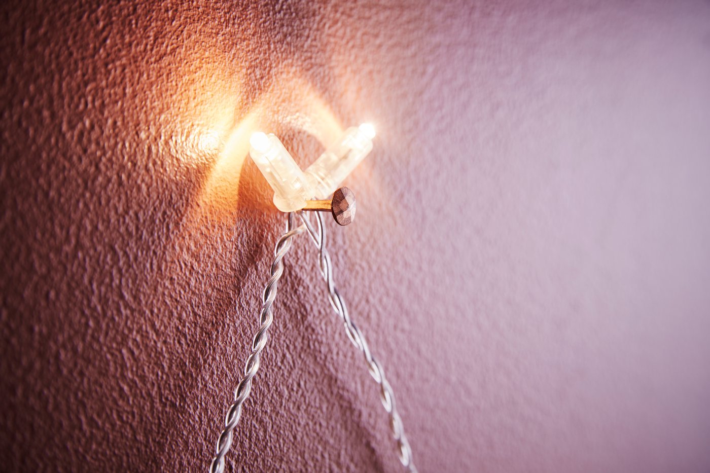 Hange your light chain on the wall in the shape of a Christmas tree.