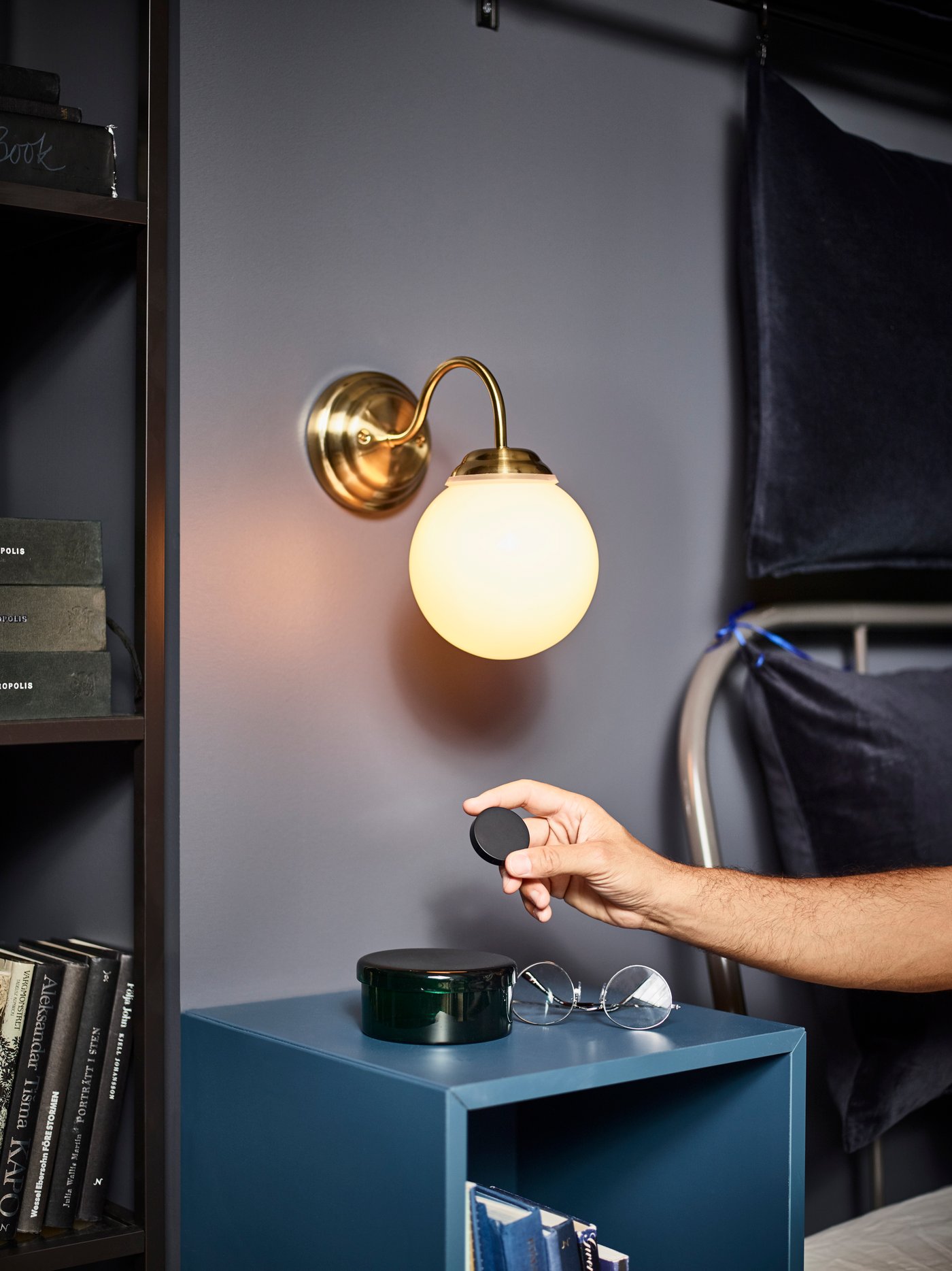 A brass-colour LILLHOLMEN wall lamp in the bedroom