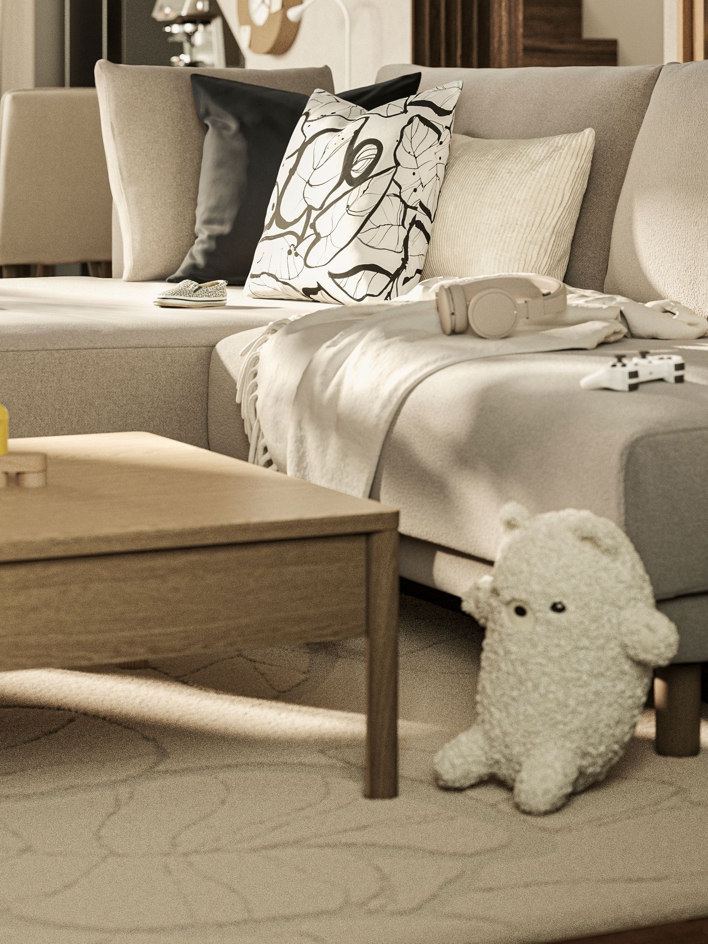 Bright living room with a beige sofa, cushions, and throws. In front of the sofa is a low wooden coffee table with wooden toys. On the rug lies a white stuffed toy, and next to it stands a shelving unit with more toys.