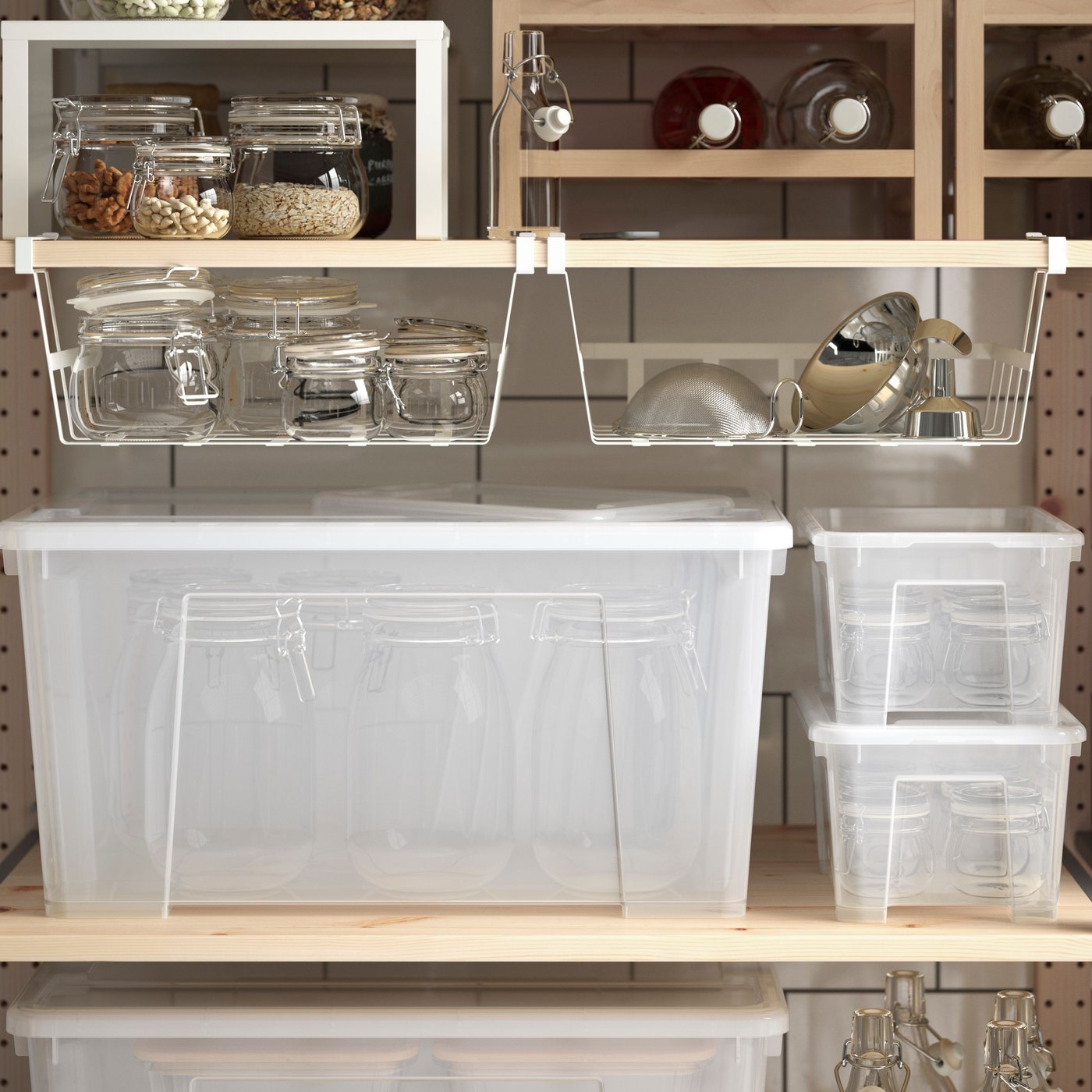 IVAR shelves of pine are standing in a white-tiled pantry and they have glass jars and plastic containers stored on them.