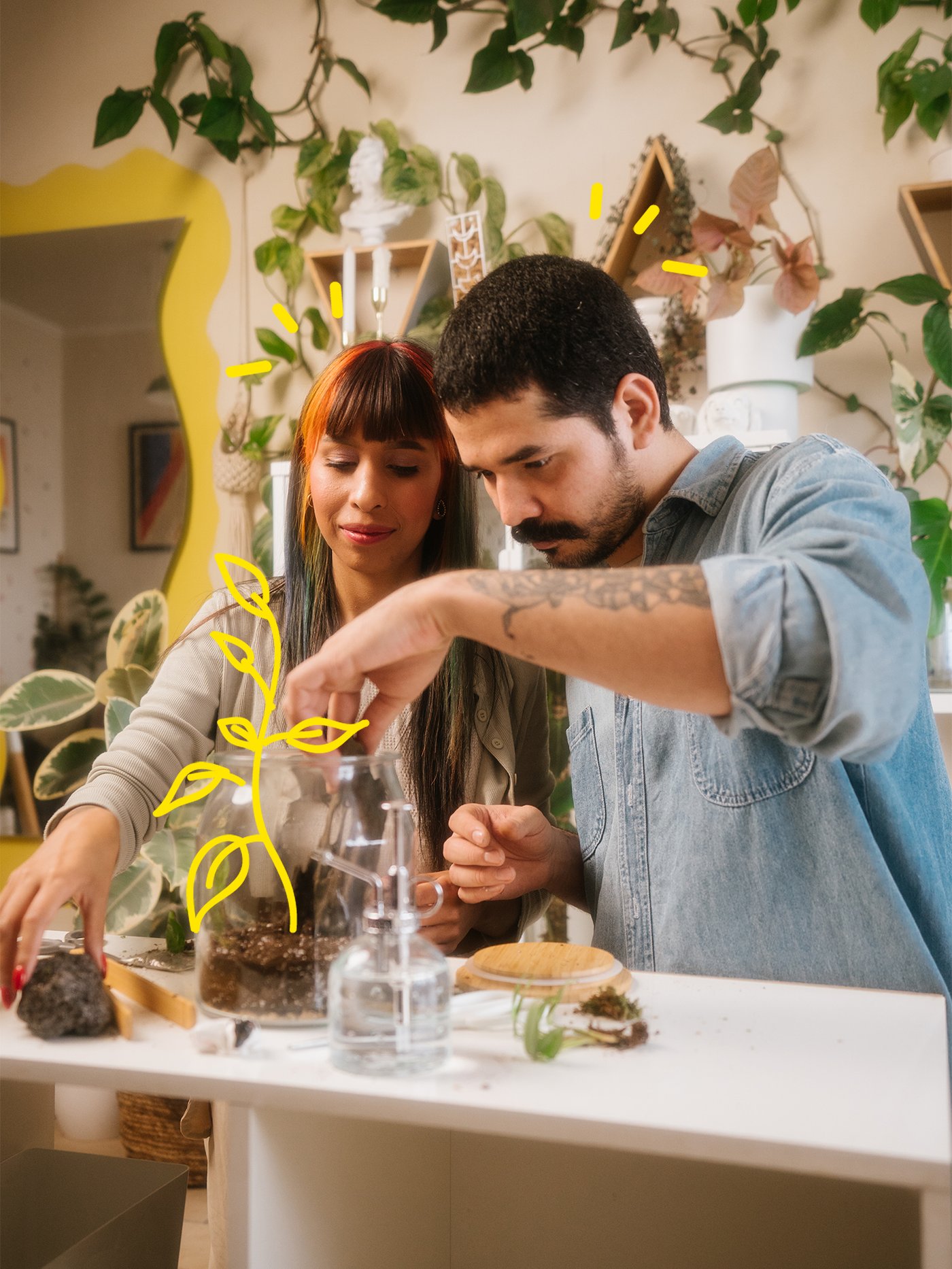 A man and a woman placing plants in soil in a glass jar.