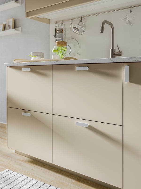 Close-up of base cabinet with HAVSTORP matt beige drawers.