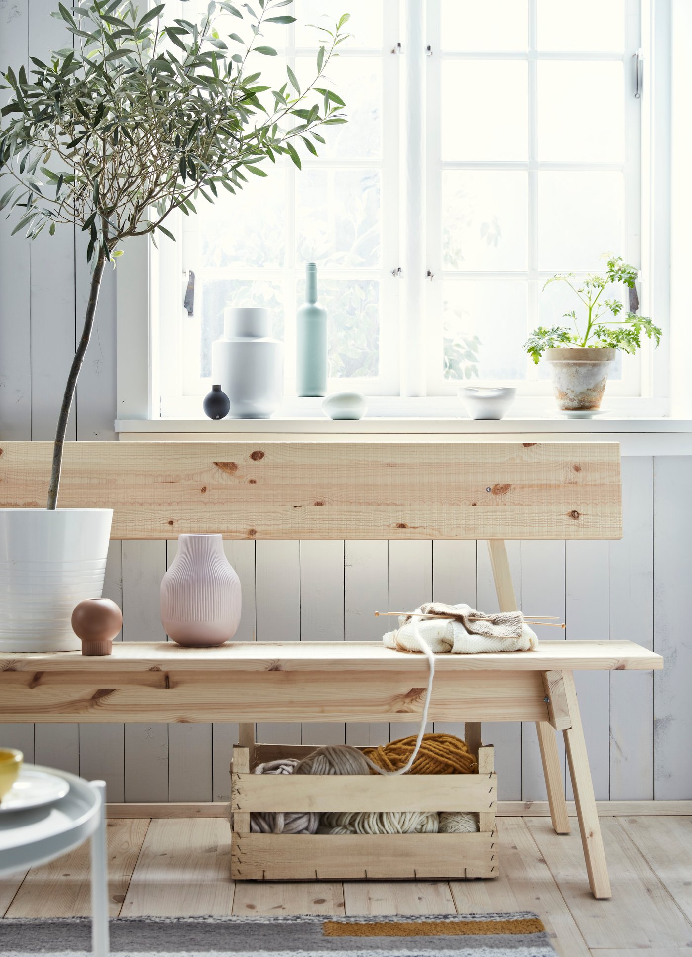 Un banc et une table INDUSTRIELL en pin, posés près d’une fenêtre dans une cuisine bien éclairée.
