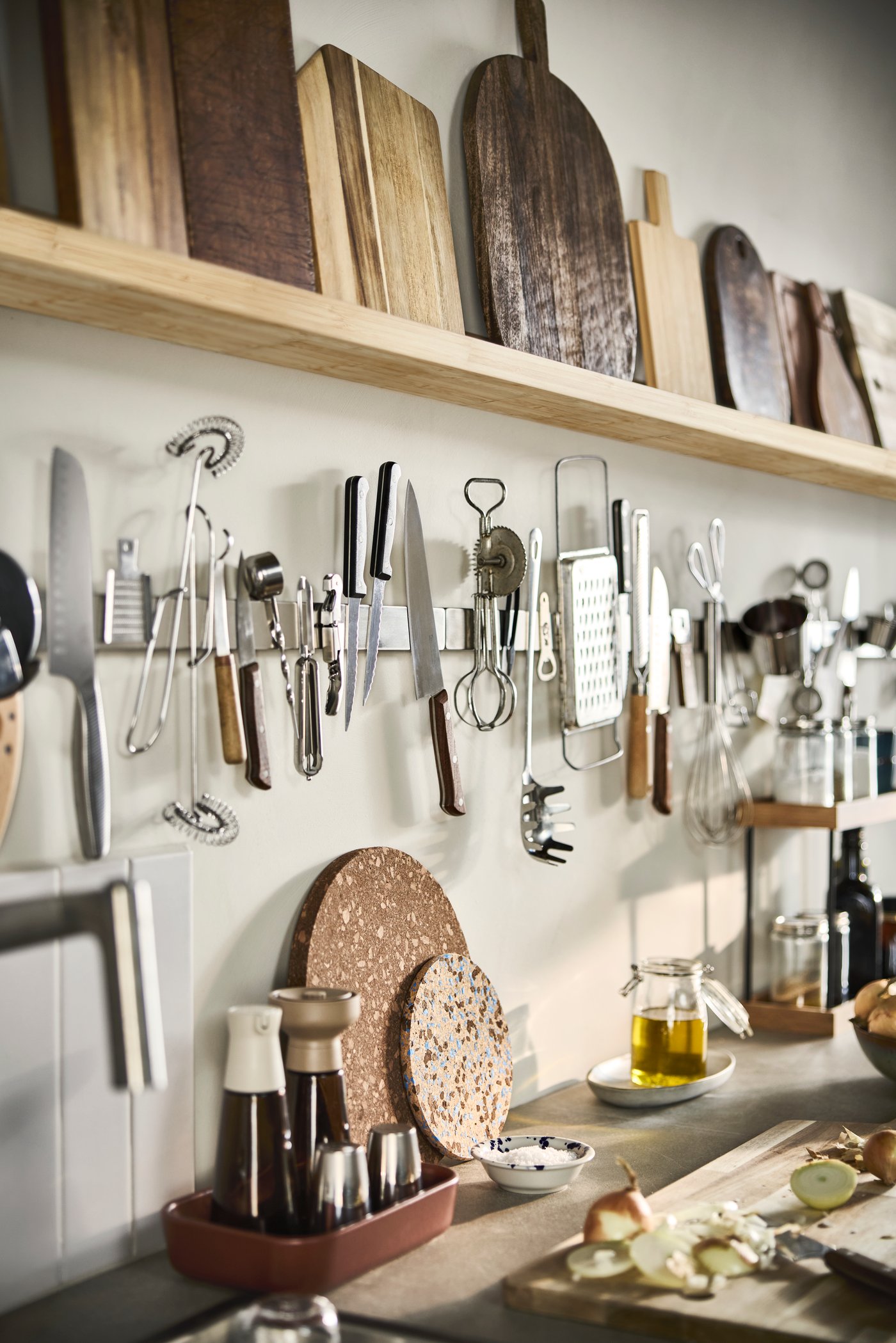 KUNGSFORS magnetich racks used to organise kitchen utensils, knives and small tools on a wall above a kitchen worktop.				