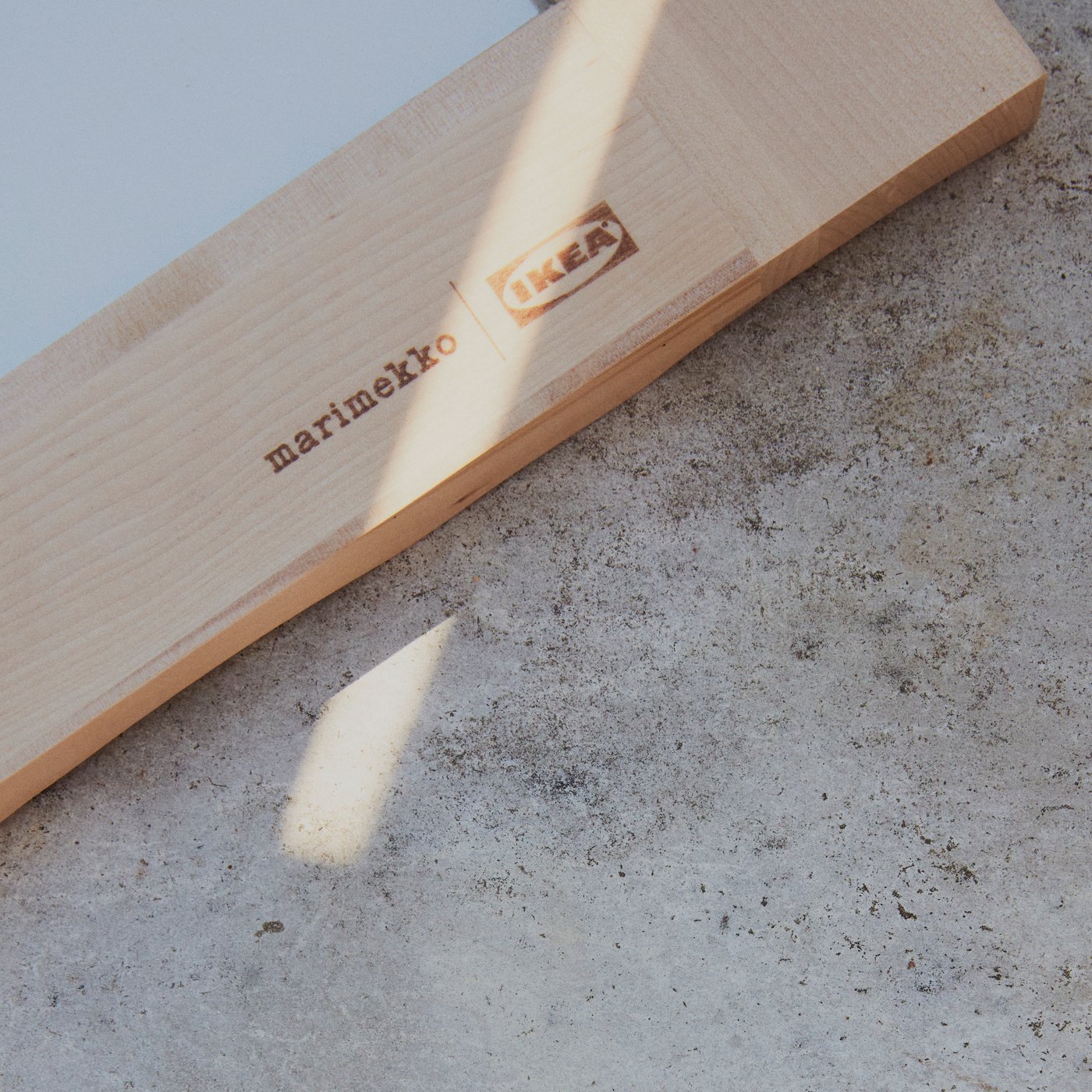 A hand refills a BASTUA water bottle with a floral pattern under a tap on a steel, industrial-looking sink.