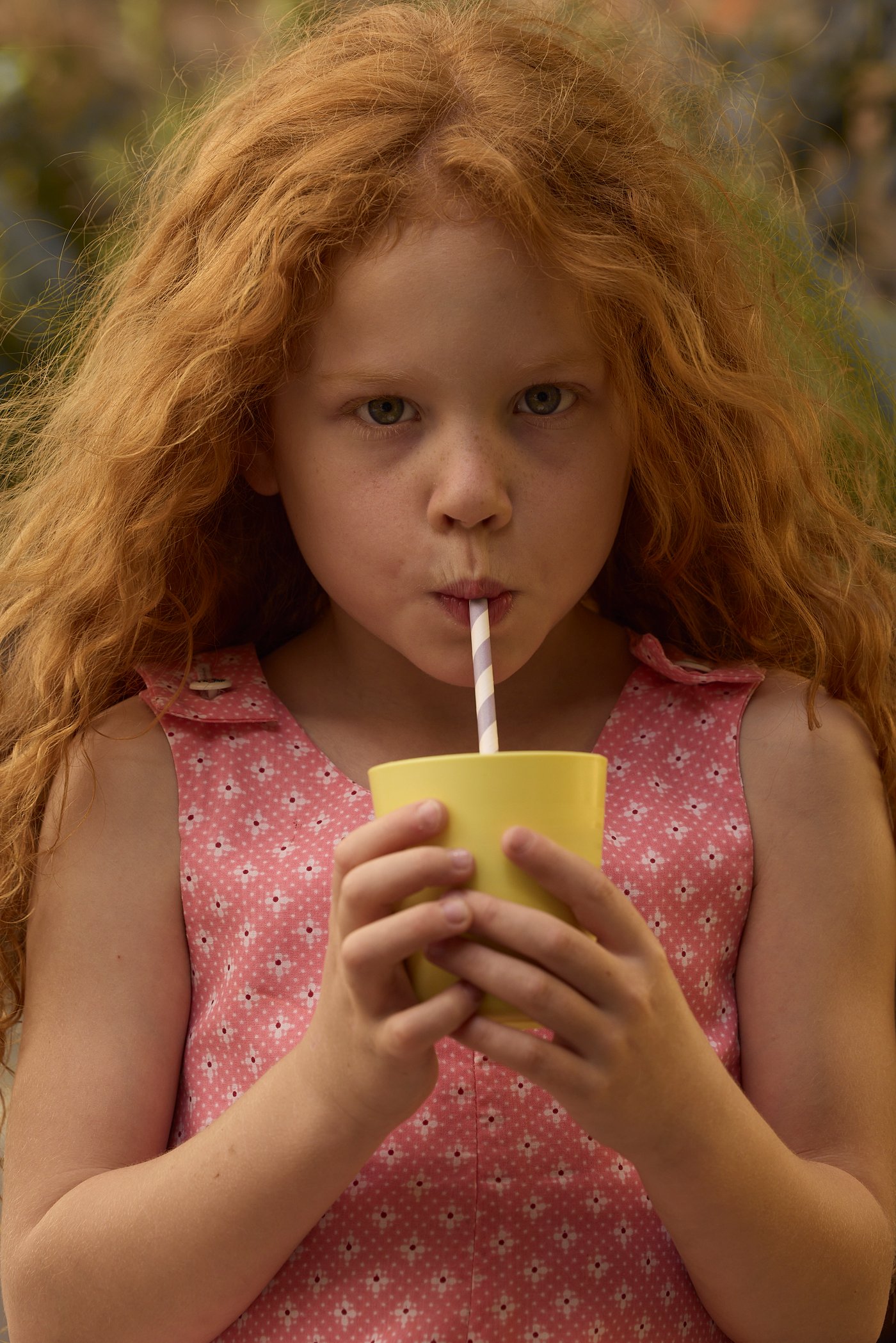 En jente drikker av en barnekopp.