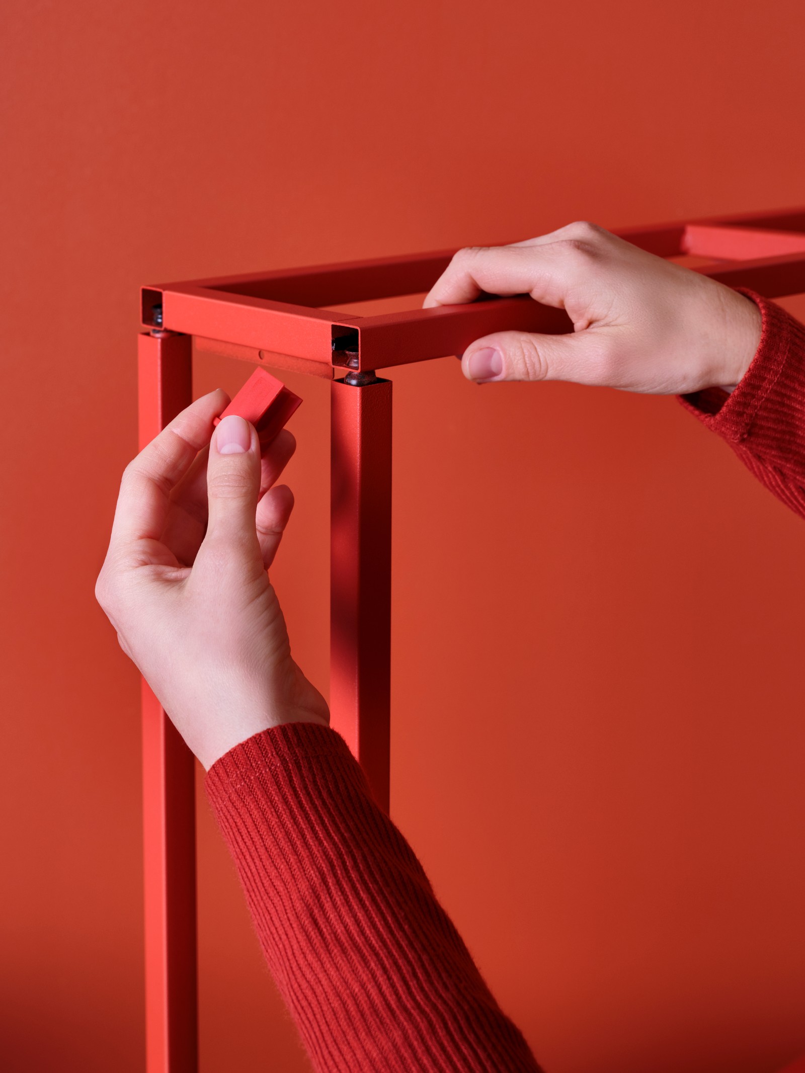 dłonie skręcające czerowną szafkę