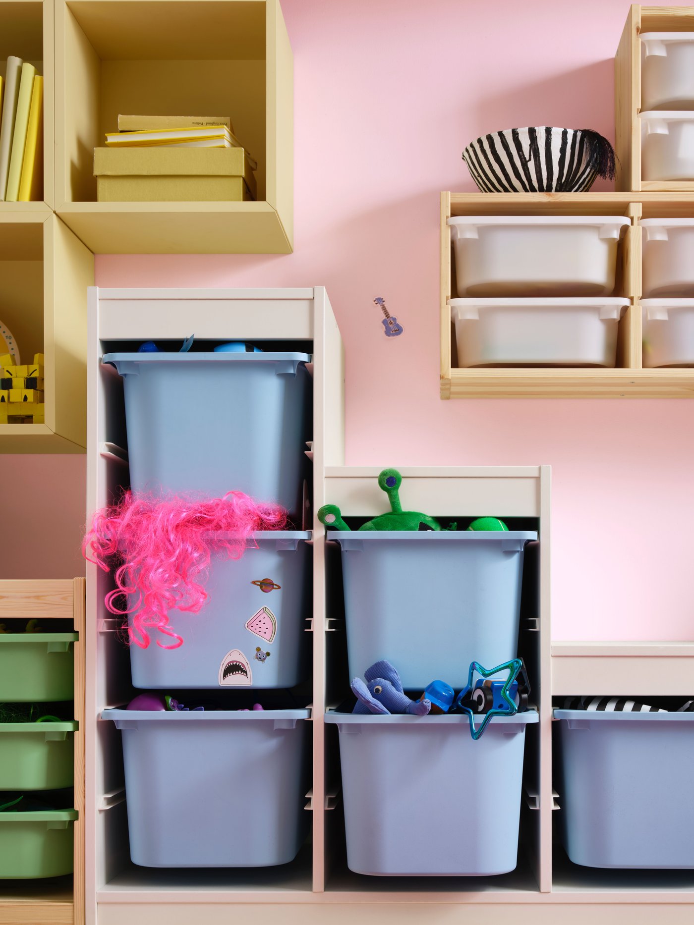 In the children's room, a white TROFAST storage unit with blue boxes is complemented by a pine TROFAST wall storage featuring white boxes.