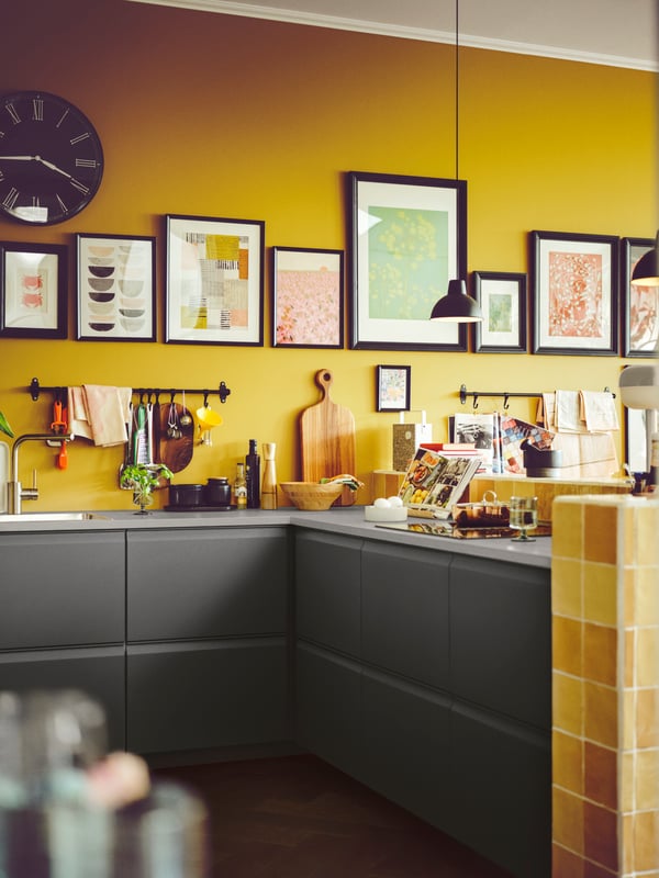 The corner of a kitchen with UPPLÖV drawers and a light grey worktop holding jars, cookbooks, a bowl and a chopping board.
