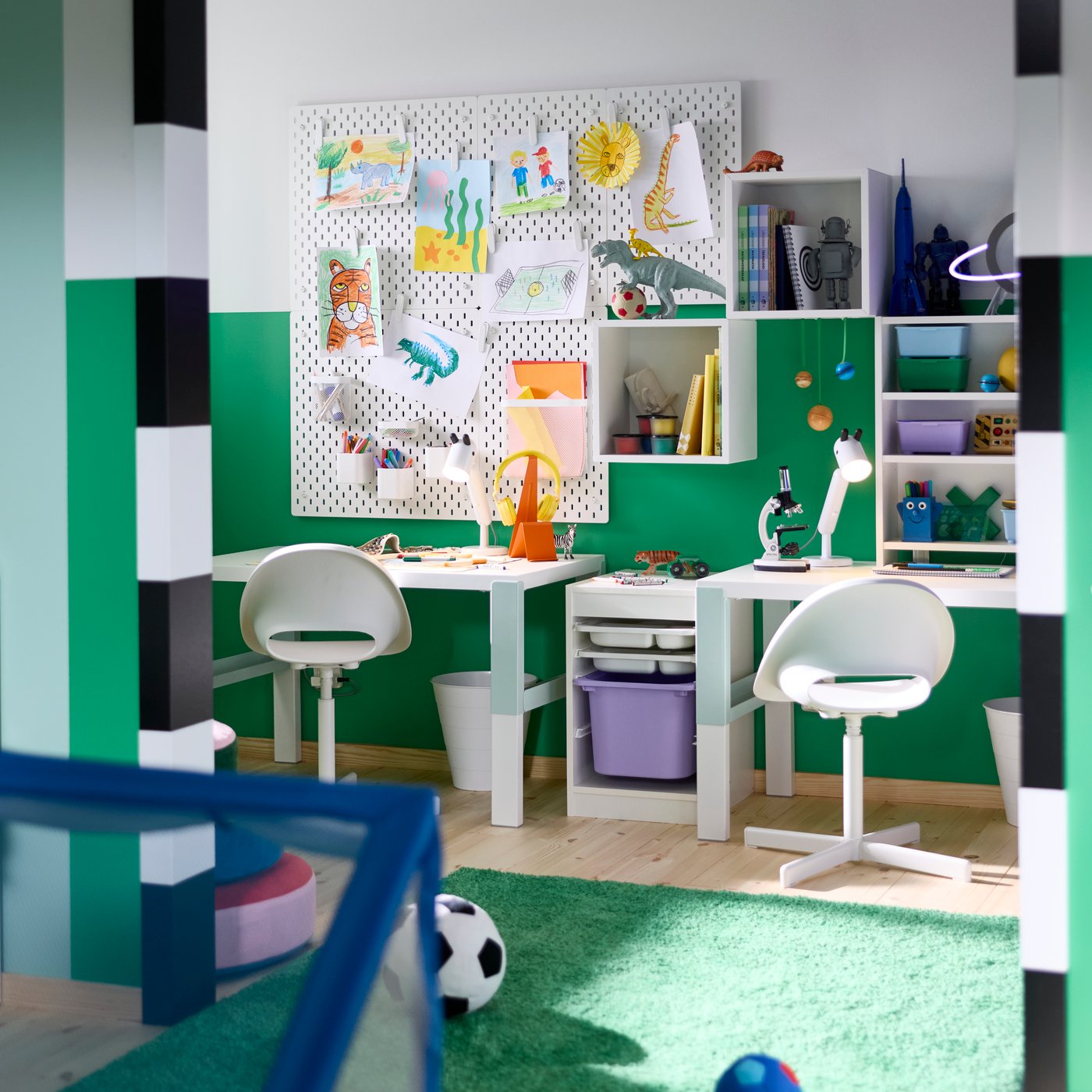 A children’s study area with a PAHL desk and two chairs, with storage boxes and wall organisers holding craft materials.