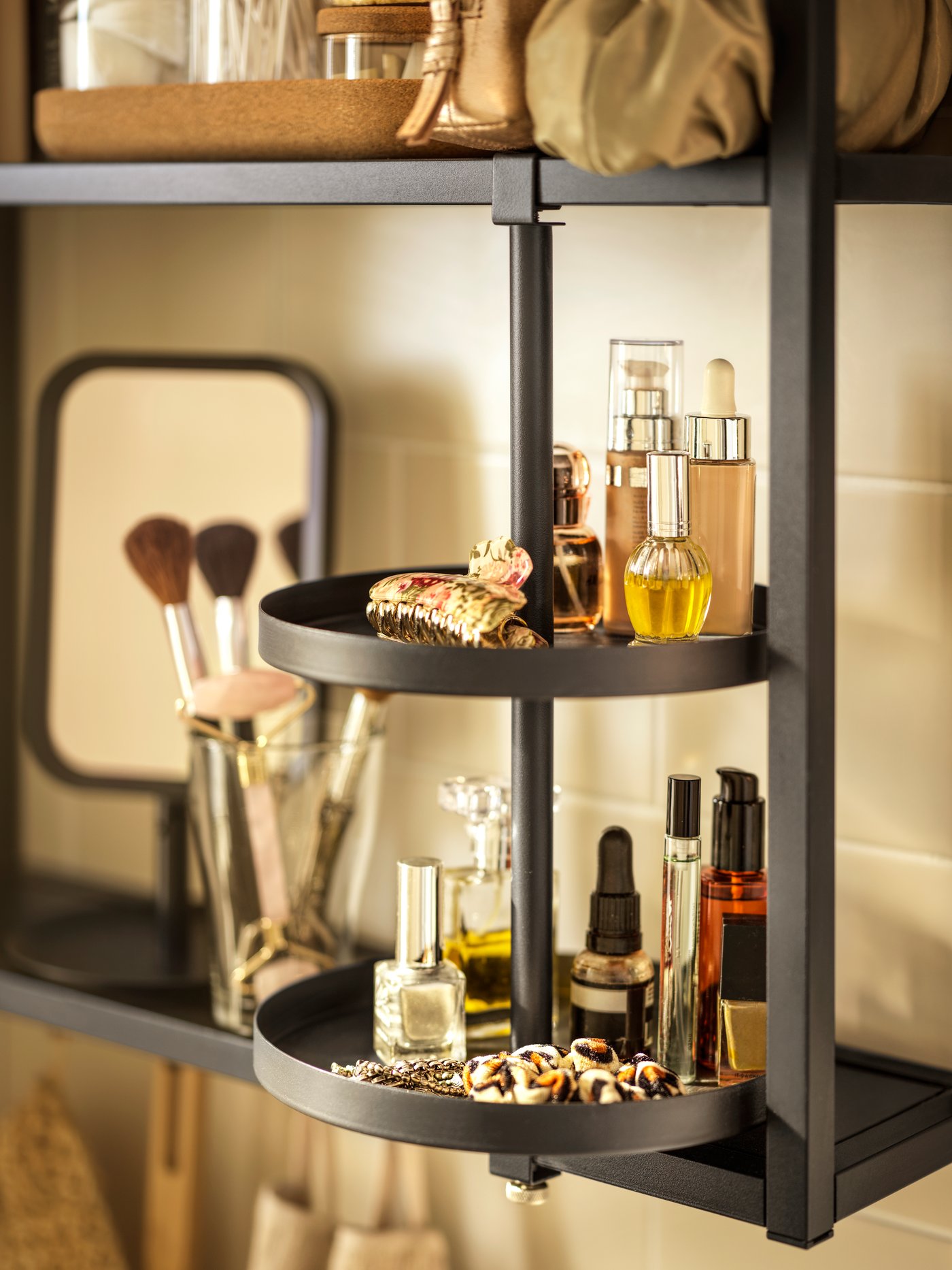 An ENHET wall frame with shelves in anthracite, and an ENHET swivel shelf in anthracite, both holding diverse bathroom items.