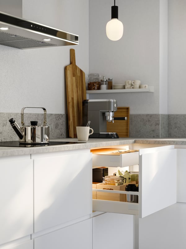 Smart lightning in a bright kitchen with one open drawer with coffe and tea.