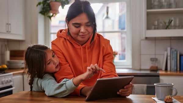Una madre e sua figlia guardano sorridenti un tablet e guardano la newsletter IKEA Family.